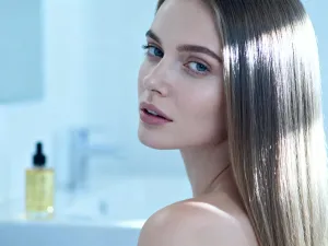 Kobieta z modną grzywką, która optycznie zmniejsza wysokie czoło, pozująca w nowoczesnym salonie fryzjerskim.
